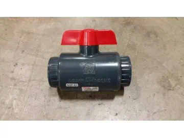 Red-handled PVC ball valve on concrete floor.