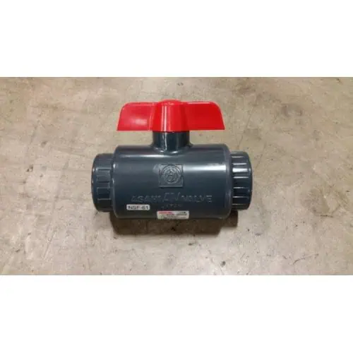 Red-handled PVC ball valve on concrete floor.