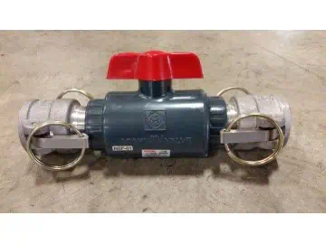 Industrial valve with red handle on concrete floor.