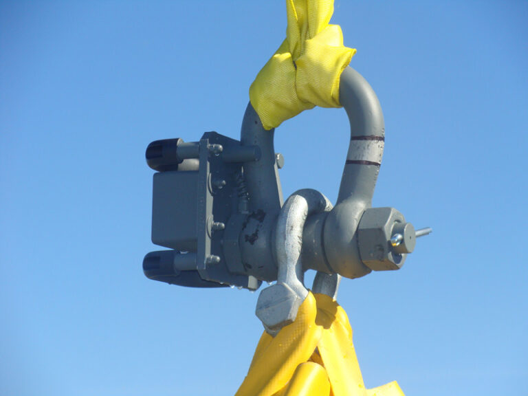 Industrial lifting hook against blue sky.