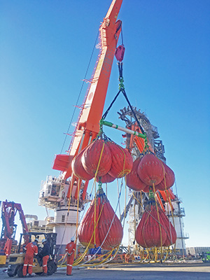 Heavy-duty crane lifting large equipment bags.