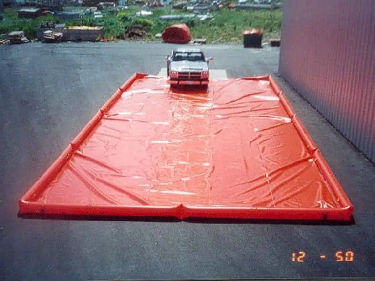 Vehicle on large red spill containment mat