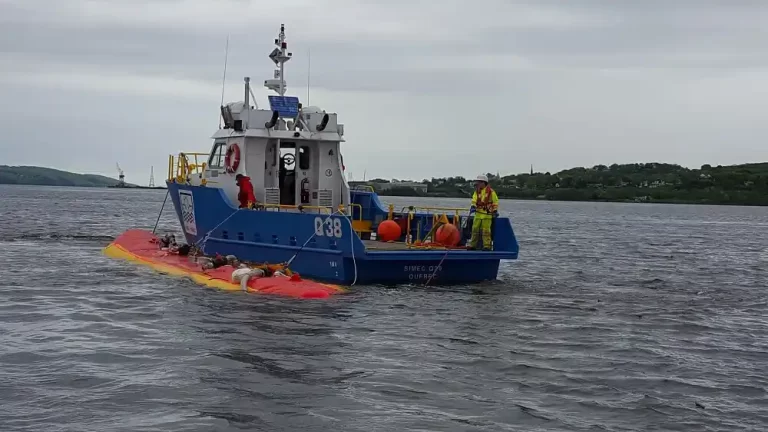 Blue boat with workers on water.