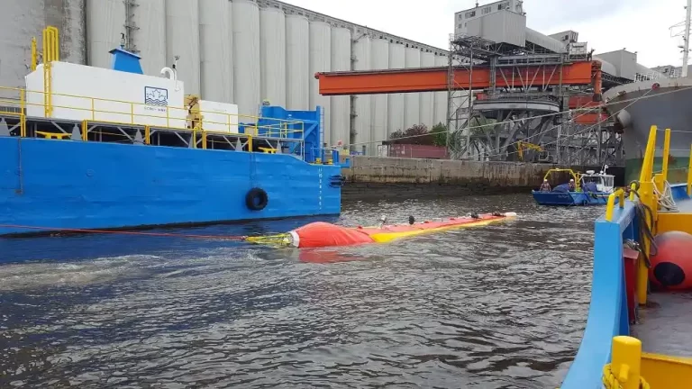 Oil spill containment booms in industrial harbor.