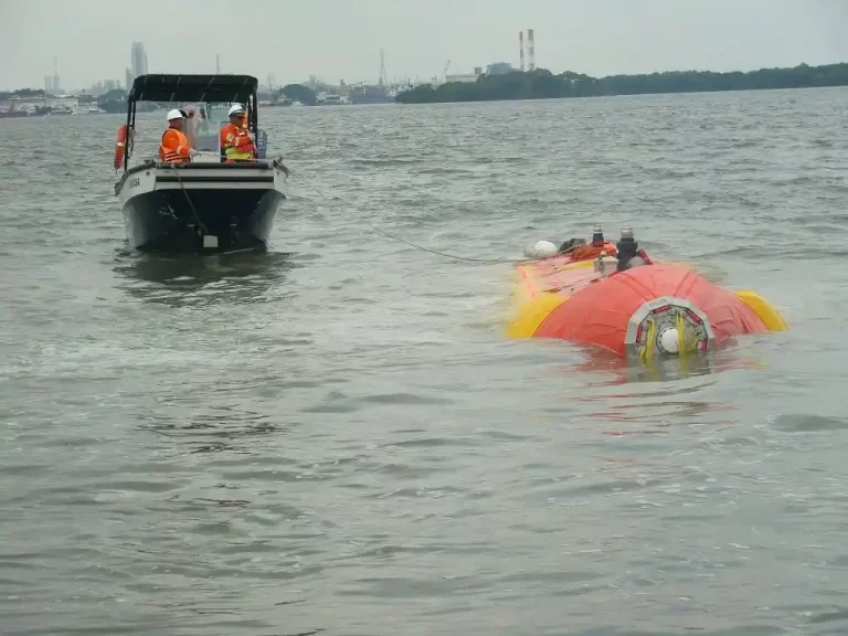 Boat towing semi-submerged vessel in open water.