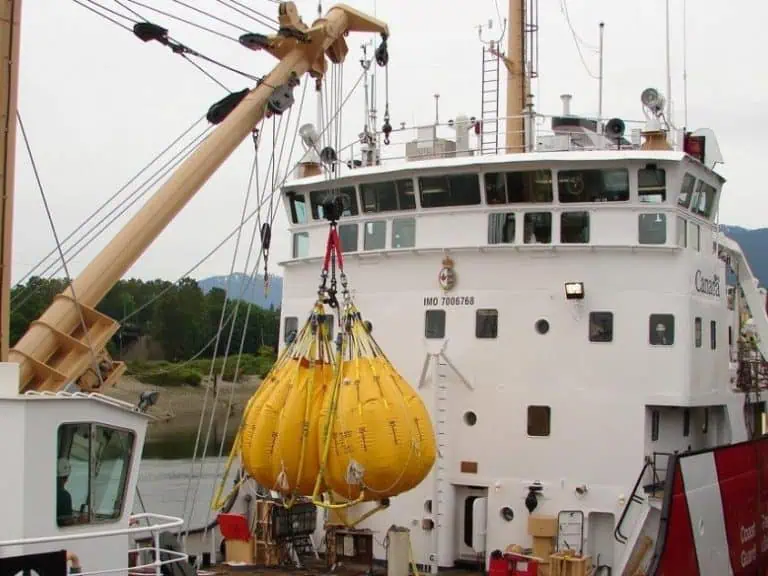 Ship lifting yellow buoys with crane