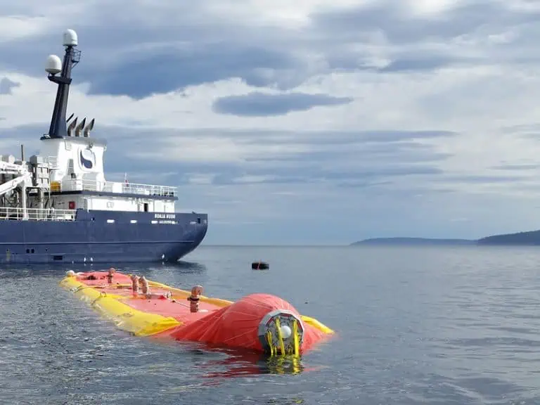 Rescue training near a research vessel at sea.