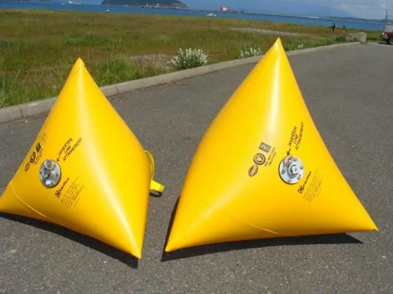 Two yellow inflatable buoy markers on sidewalk.