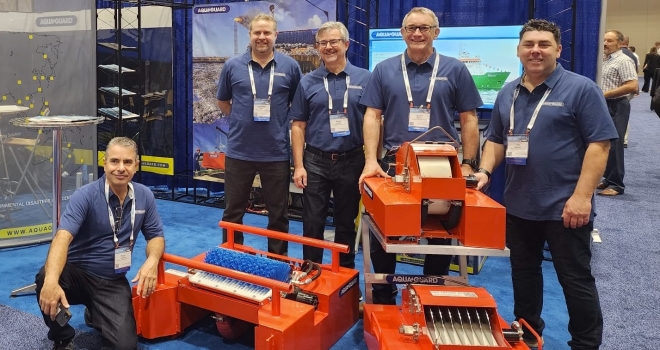 Group with industrial equipment at a trade show.