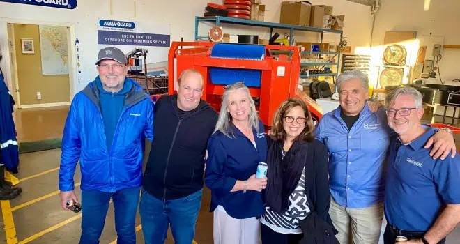 Group of conference attendees smiling in an industrial warehouse