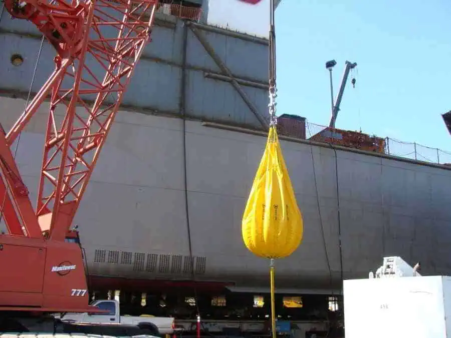 Crane lifting a large yellow water bag