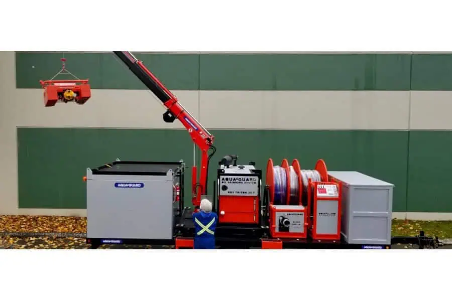 Worker operating AquaGuard oil skimming system crane