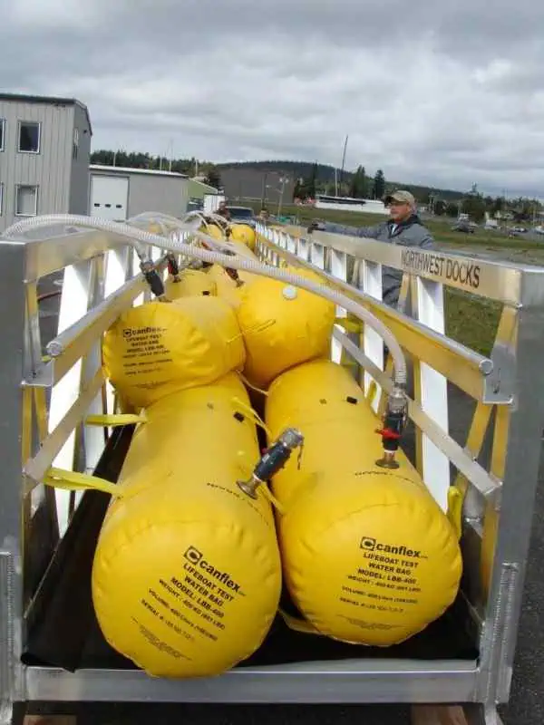Yellow lifeboat test water bags on metal frame