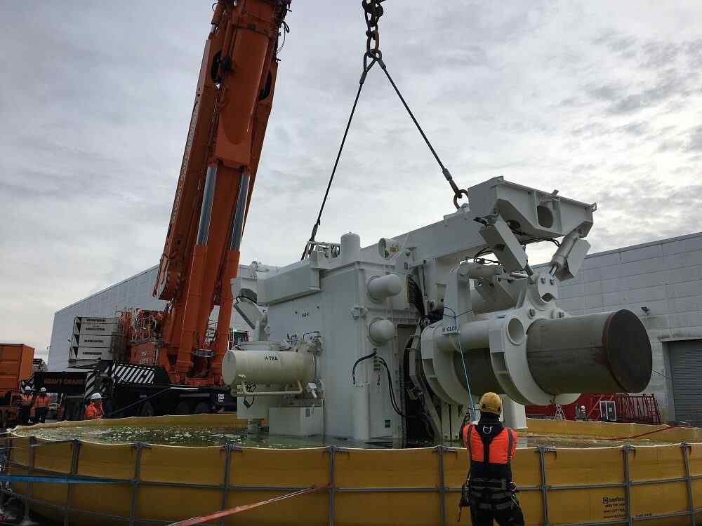 Large crane lifting industrial machinery outdoors