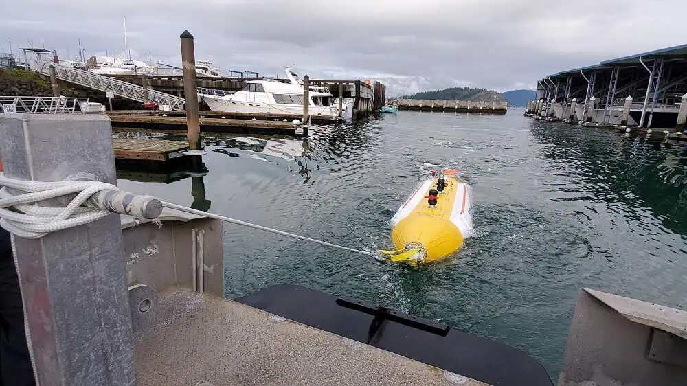 Yellow underwater vehicle tethered near marina dock