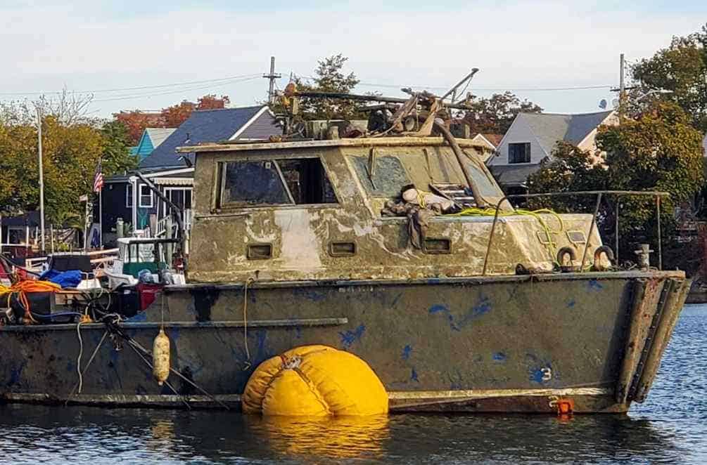 Old fishing boat docked near houses by water