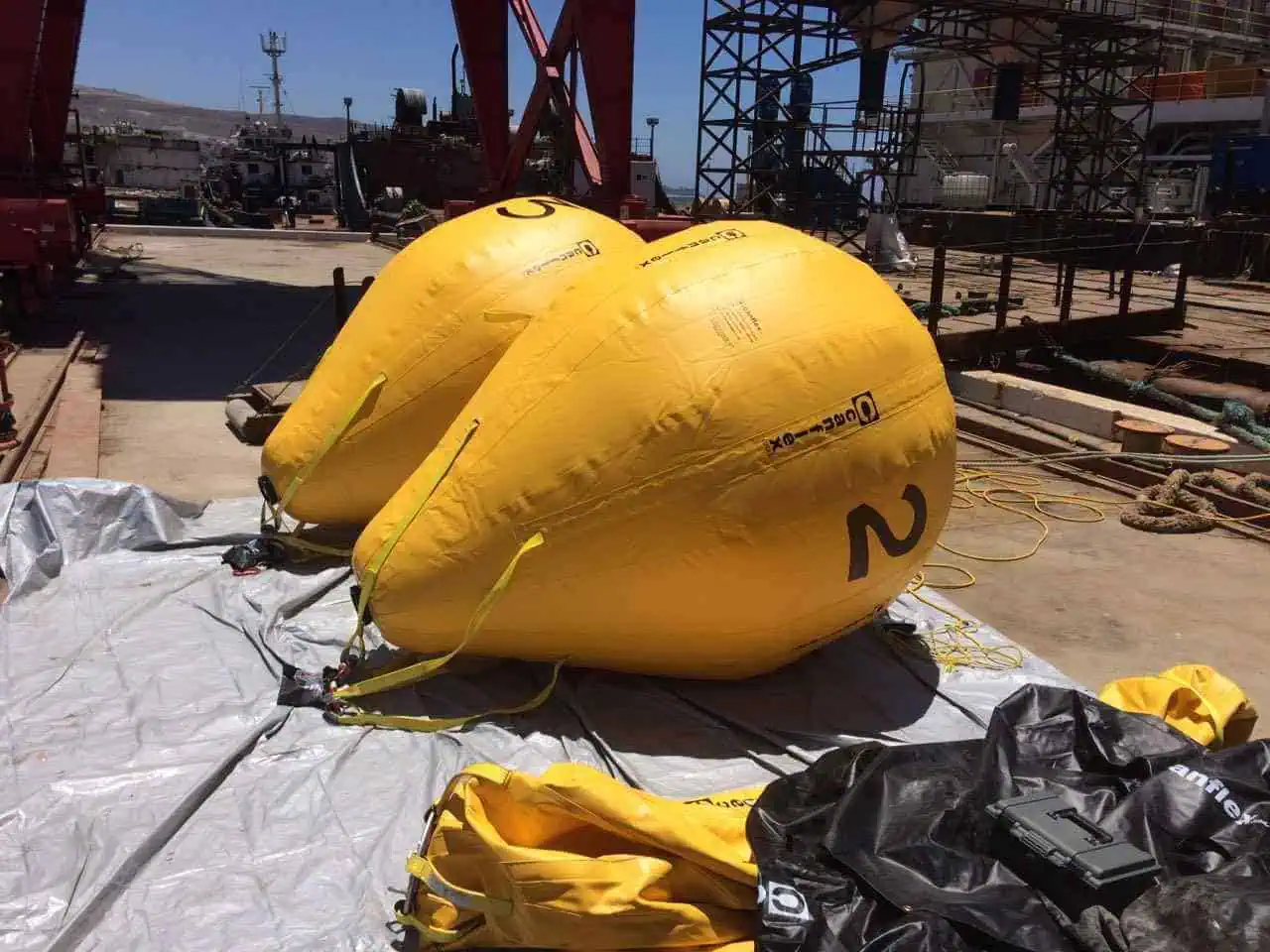 Large yellow lifting bags on a shipyard dock