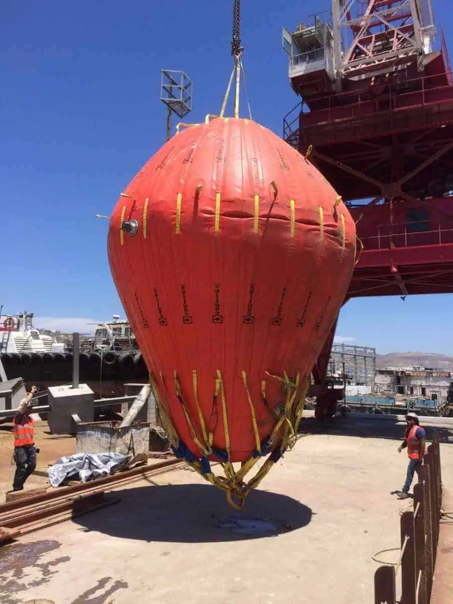 Large red water bag lifted by crane