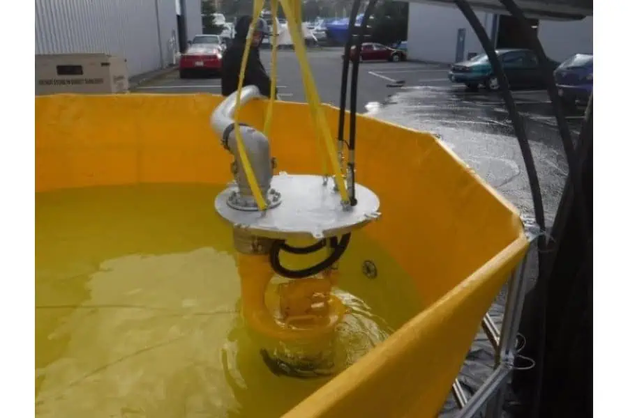 Industrial pump submerged in yellow test tank