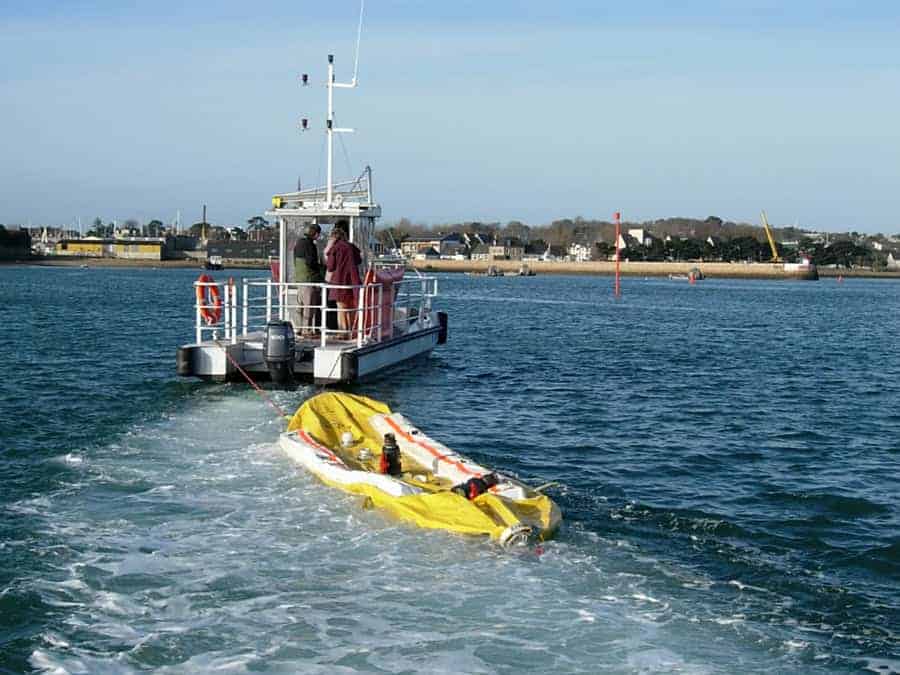 Boat towing inflatable raft in harbor