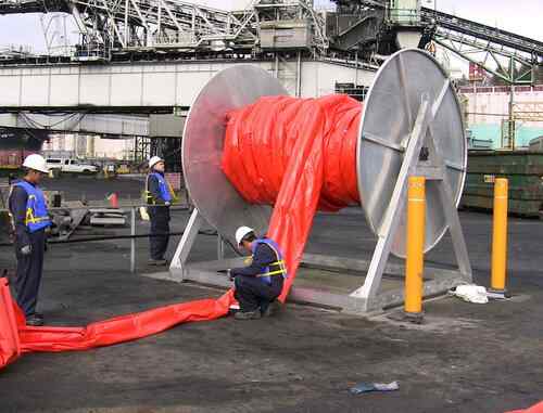 Workers handling large industrial cable spool outdoors