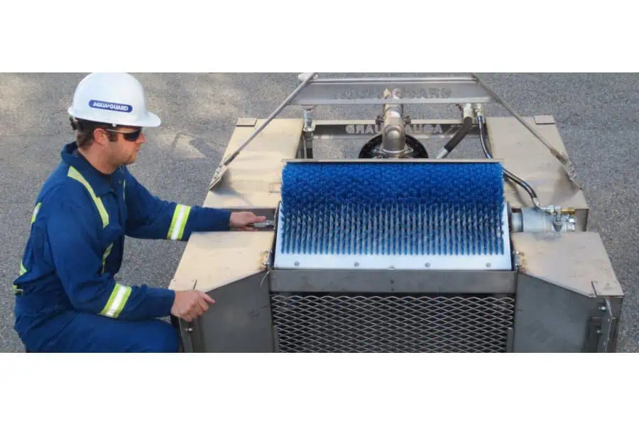 Worker operating industrial cleaning brush machine