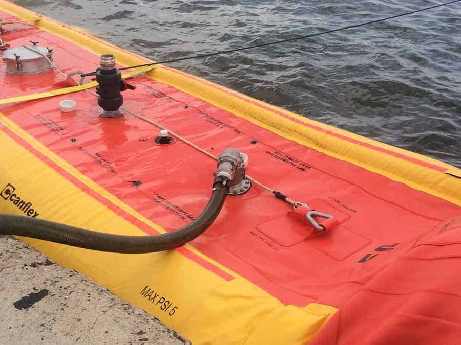 Inflatable liquid storage tank beside water.