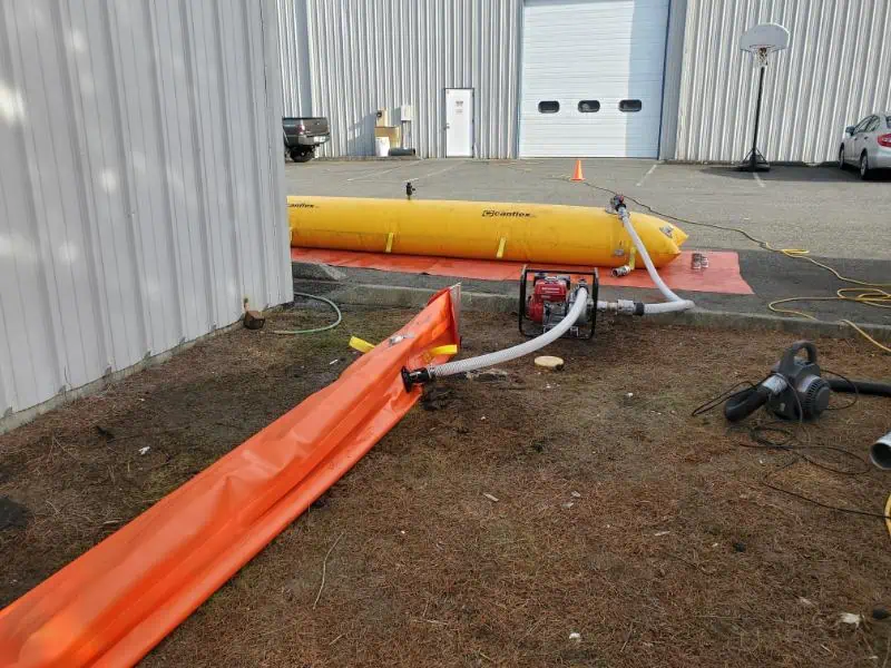 Water pump setup with hoses outside industrial building