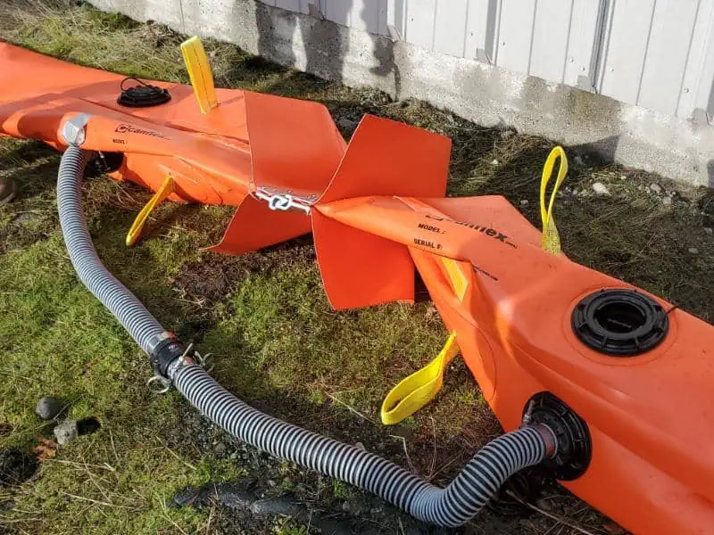 Orange water-filled flood barrier with attached hoses