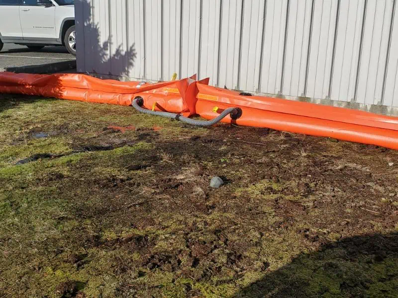 Orange drainage pipes beside metal building wall