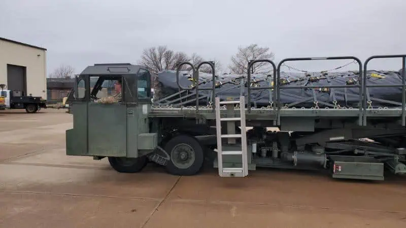 Military cargo loader transporting secured supplies outdoors