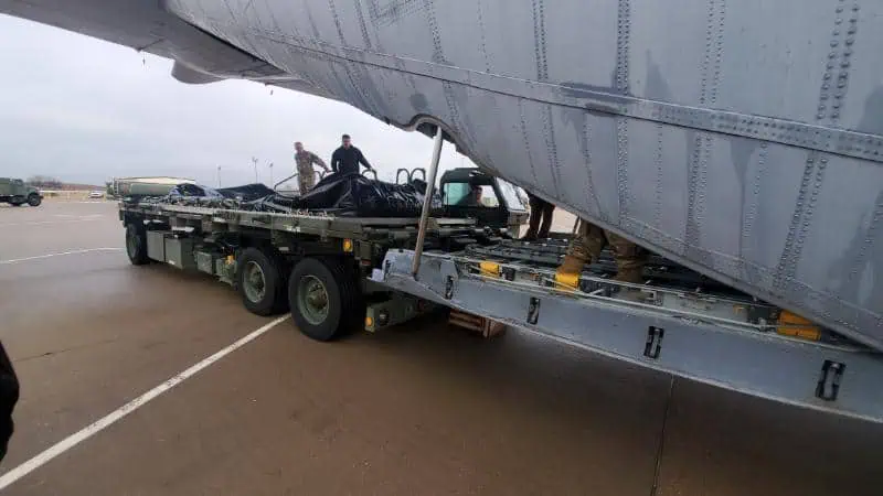 Workers loading cargo onto military transport aircraft