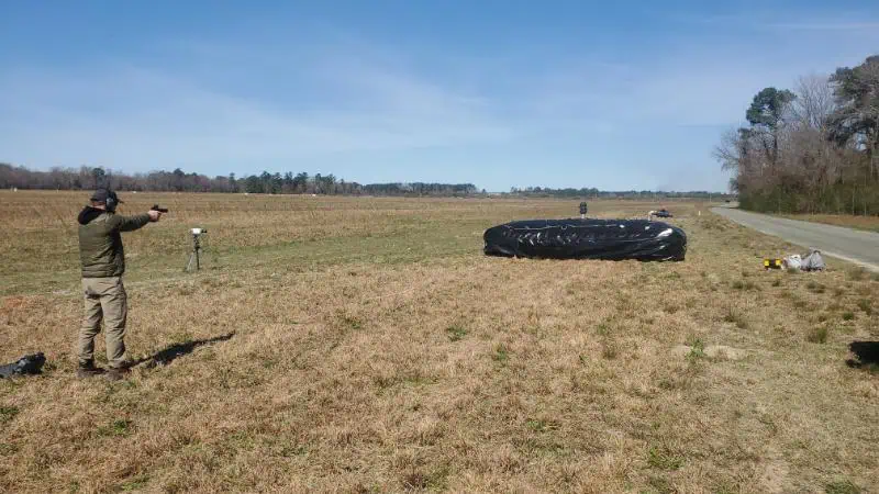 Person shooting at target in open field