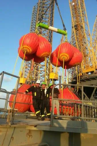 Workers testing offshore crane with load test bags