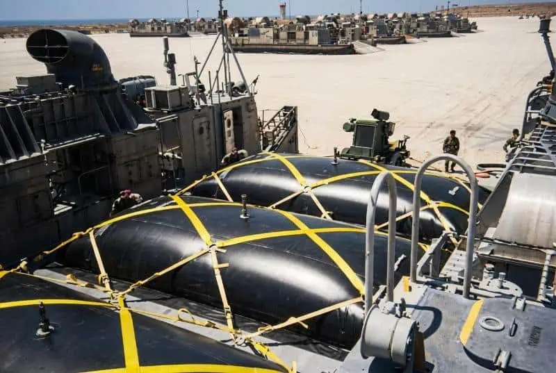 Military landing craft with large black cargo bags