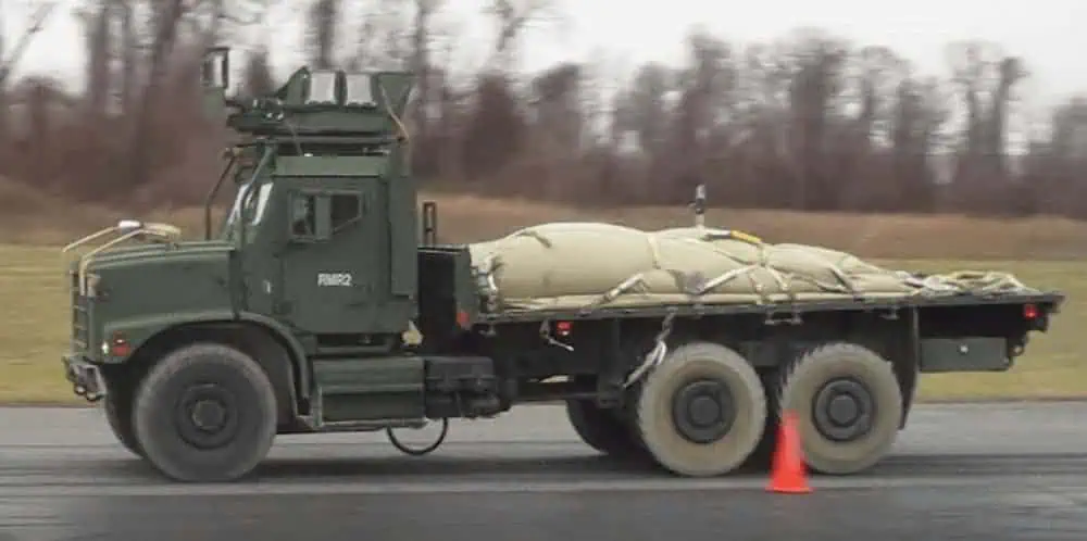 Military truck carrying large covered cargo