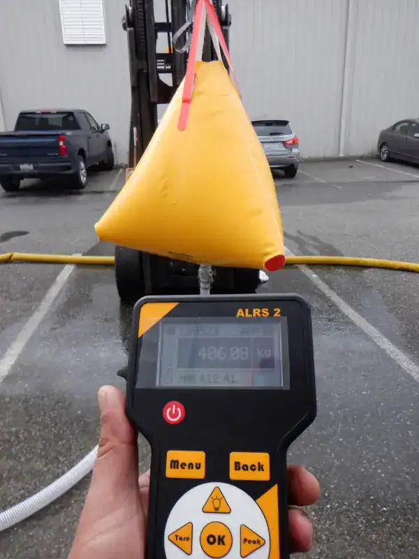 Handheld scale measuring yellow lifting bag weight