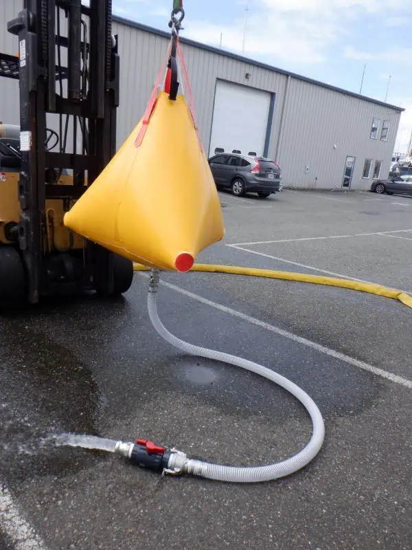Forklift lifting yellow water bladder draining hose