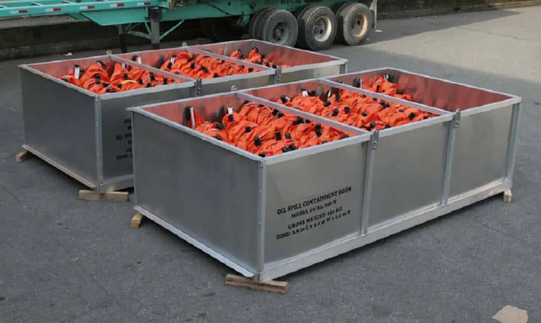 Metal containers holding orange oil spill booms