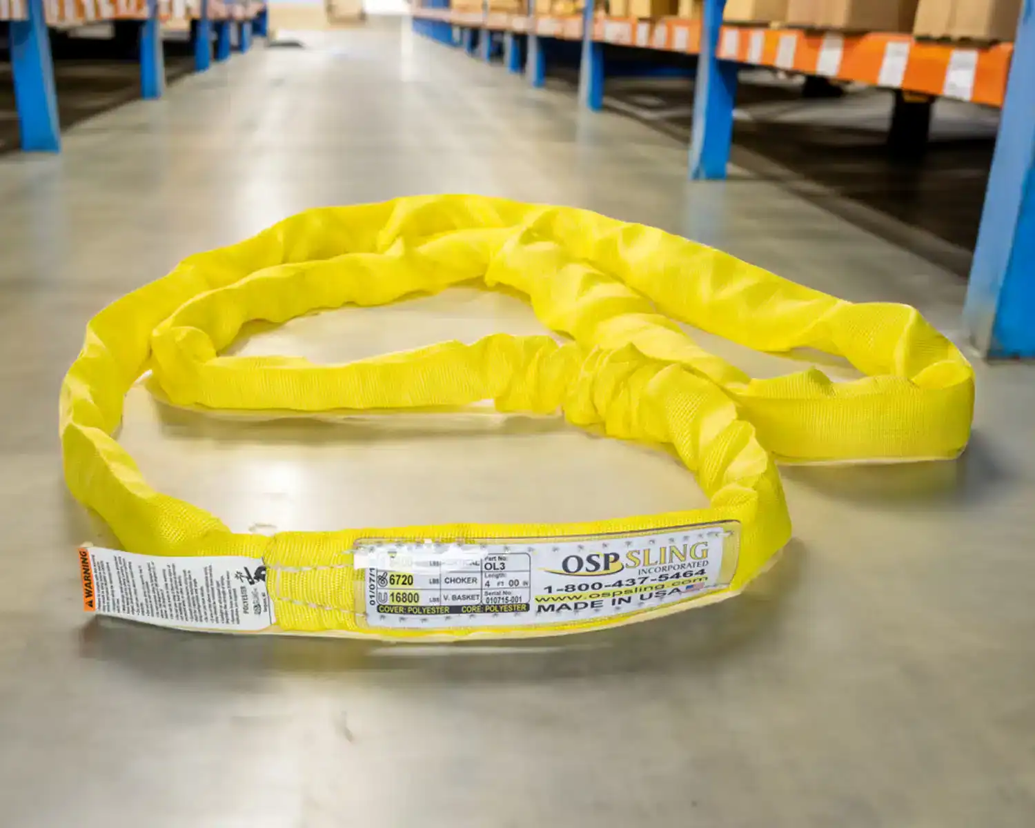Yellow polyester lifting sling in warehouse aisle