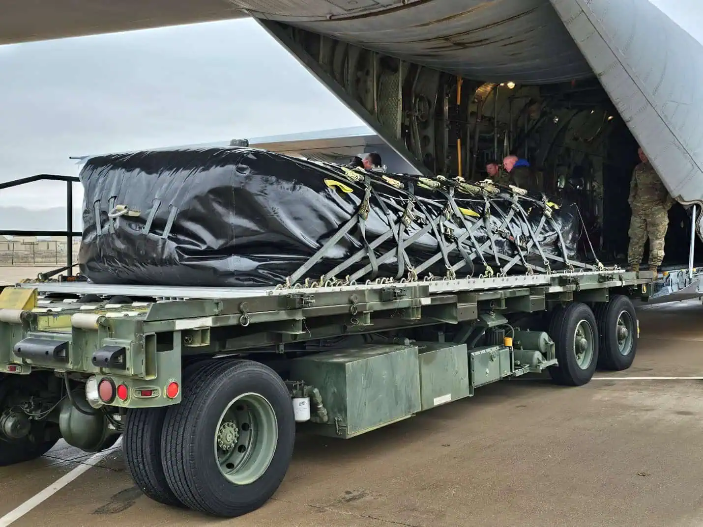 Military cargo loaded from aircraft onto trailer