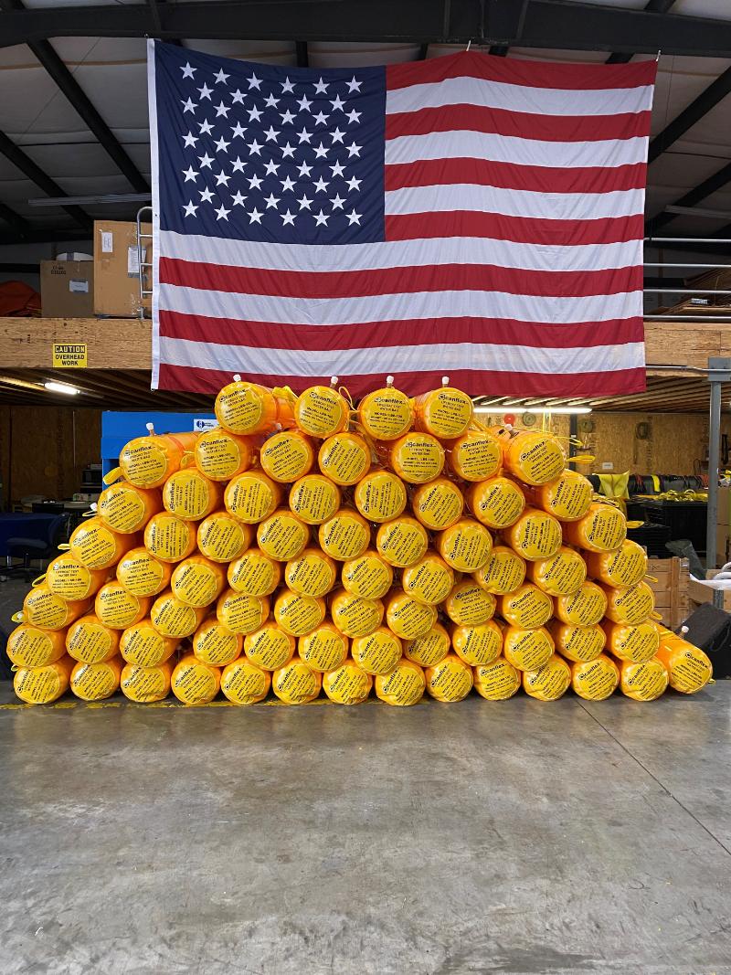 American flag above stacked yellow flotation devices in warehouse